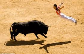 man flys towards bull