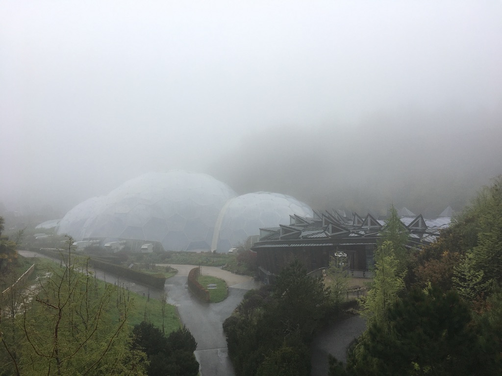 The Eden Project, the Core building and the smaller biome, nestled into the hillside in the mist