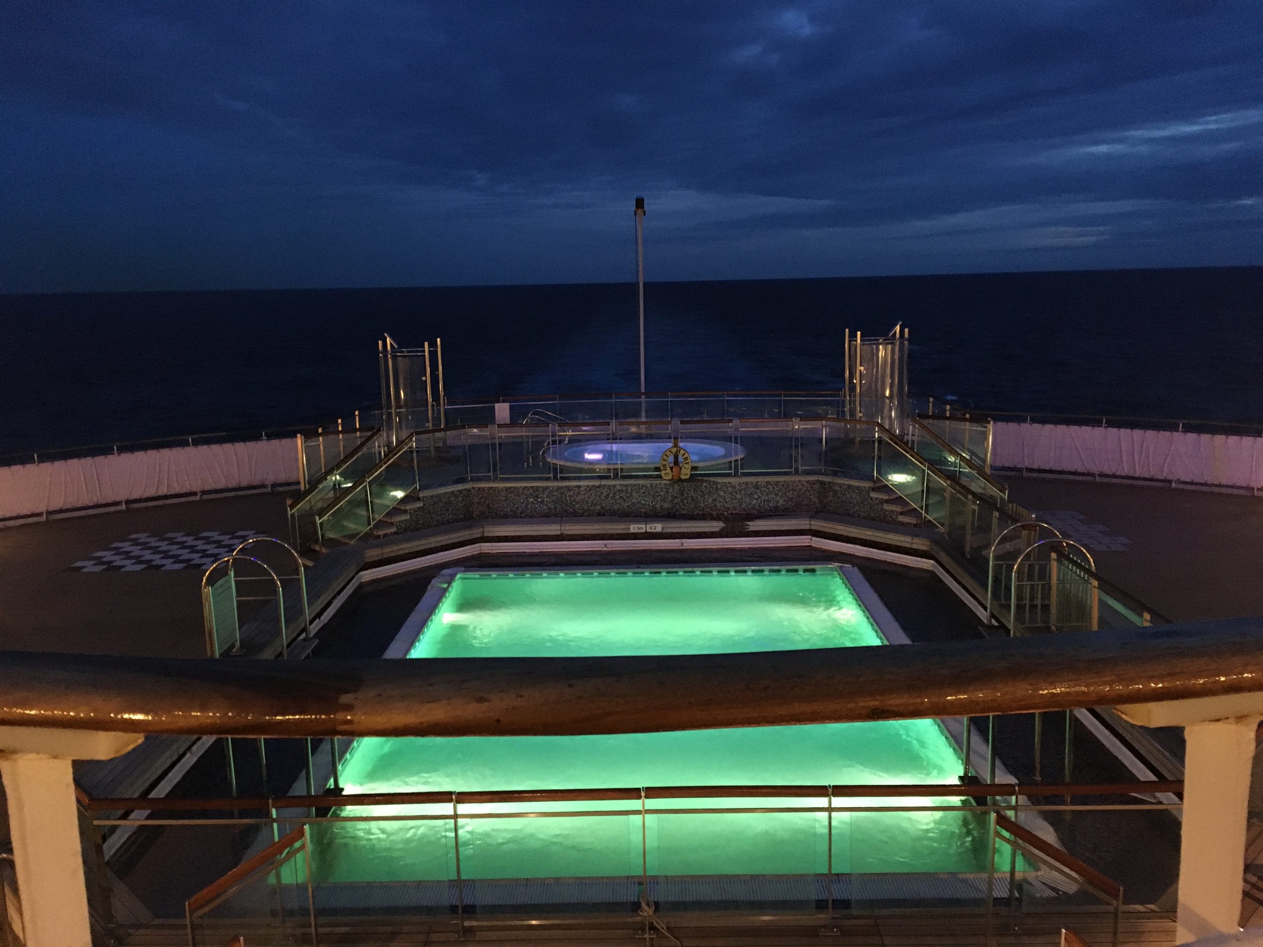 After hours Jacuzzi and pool on Deck 6 QM2 showing net covering and garish colours