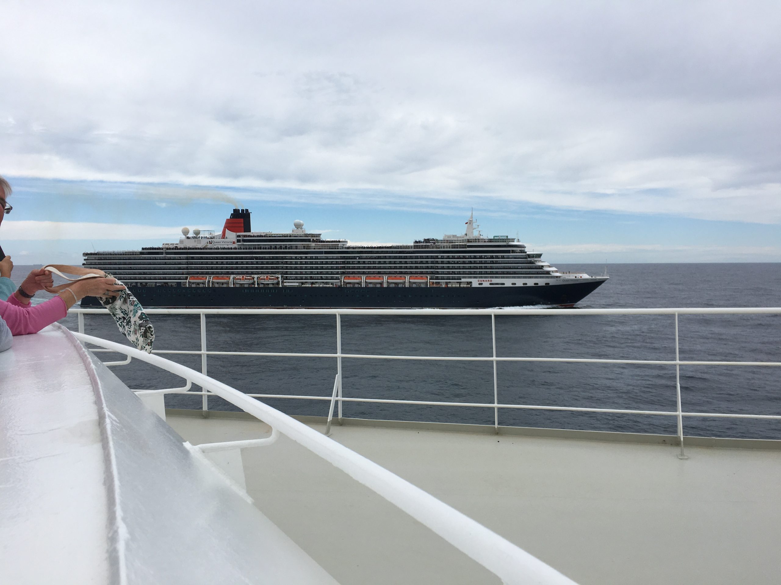 Queen Victoria lets out loud whistles, toots and cheers. QM2 replies. Loudly.